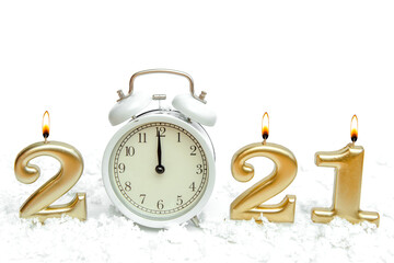 white clock alarm clock shows 12 o'clock midnight as zero numbers 2022 from golden candles in snow on white isolated background