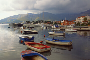 Fototapeta premium Beautiful Mediterranean landscape with boats on water. Montenegro, Adriatic Sea, view of Bay of Kotor near Tivat city on cloudy autumn day