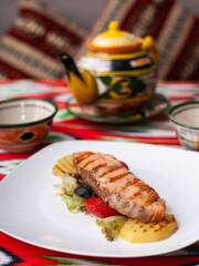 Salmon steak on a pillow of stewed vegetables. Asian style