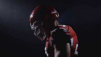 Profile portrait of determined professional American football player in helmet ready for game and attack. Confident and agressive man in uniform. Usa team game and extreme sport spirit concept.