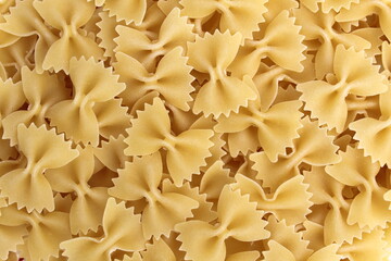 Texture of golden pasta in the form of bows for cooking lunch