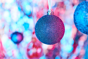 Blue xmas decoration covered with silver glitters hanging in front of camera
