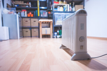 Heating the basement with electric heater. Blurry boxes and shelfs in the background