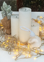 Fototapeta na wymiar New Year's composition, consisting of white candles and glowing bulbs. New Year and Christmas concept