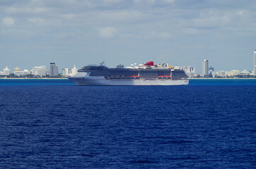 Modern Carnival cruiseship or cruise ship liner on blue sea ocean in front of skyline of Miami SOBE...