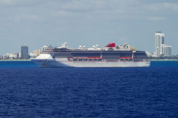 Modern Carnival cruiseship or cruise ship liner on blue sea ocean in front of skyline of Miami SOBE...
