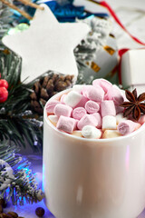 Obraz na płótnie Canvas Winter hot drink, gift boxes and Christmas garland. Mug of hot coffee with marshmallows and anise. Christmas and New Year concept.