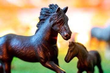 plastic figurines of wild horses on orange background