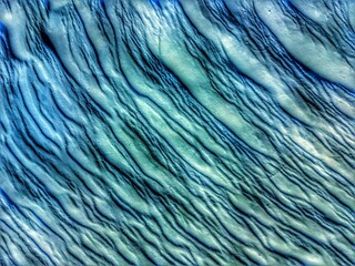 Abstract background from natural relief surface of iridescent light-blue color with abstract whimsical pattern close-up. High quality photo