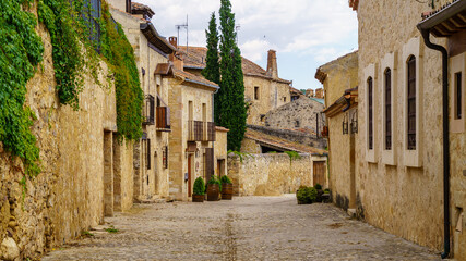 Fototapeta na wymiar Calle y casas antiguas hechas de piedra medieval en el pueblo de Pedraza en Segovia