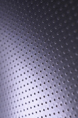 Tinted violet or purple metallic background. Dark vertical tech wallpaper. Perforated aluminum surface with many holes. Macro