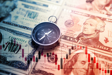 Chart graph spreadsheet on US dollar banknotes money with compass. Choosing the direction.