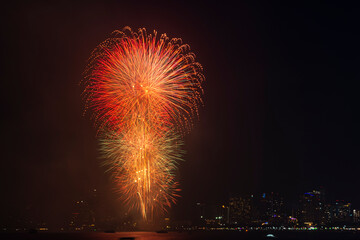 Firework festival with beach foreground and city background at Pattaya beach, Thailand. Colorful firework in celebration festival background