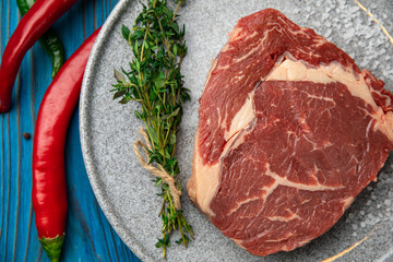 Raw Meat Sliced Pieces Of Beef With Spices And Herbs on a round plate