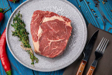Raw Meat Sliced Pieces Of Beef With Spices And Herbs on a round plate