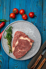 Raw Meat Sliced Pieces Of Beef With Spices And Herbs on a round plate