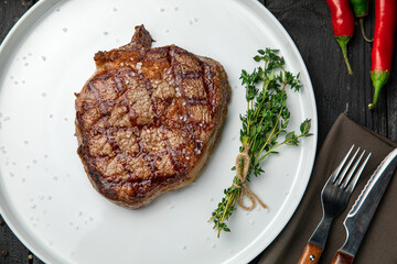 grilled steak on a white round plate.
