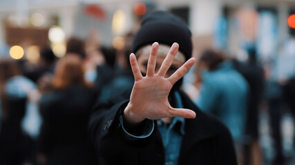 Stop. Young woman with face mask stoping camera with outstretched hand. Demonstation and protest....