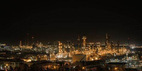 Fototapeta na wymiar Panorama of Oil and Gas refinery industry plant with glitter lighting, Factory of petroleum industrial at night time, Petrochemical plant with gas distillation tower and storage tank