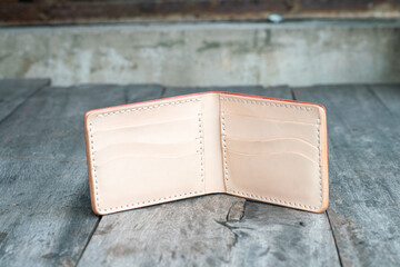 Red genuine cow leather bifold men wallet on wood