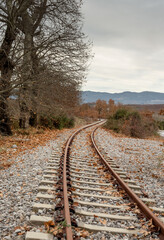 Fototapeta premium A small, railway station in the countryside at the foot of the mountains in an autumnal, overcast day (Greece, region Arcadia).
