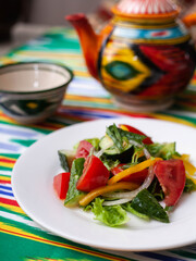 Vegetable salad of tomatoes, cucumbers, herbs and sweet pepper with butter. Asian style