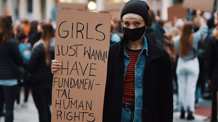 Girls just wanna have fundamental human rights. Woman march anti-abortion protest, woman holding banner in the crowd. High quality photo