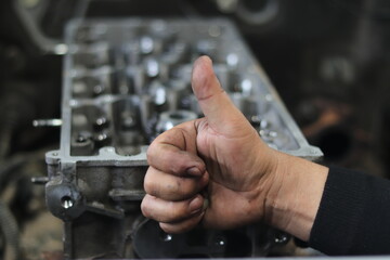 The mechanic is checking the engine.