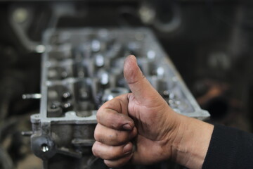 The mechanic is checking the engine.