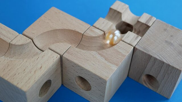 Marbles rolling on the winding path, Wooden construction with curved channel