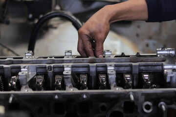 The mechanic is checking the engine.