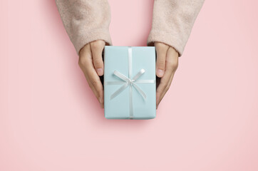 Top view of Woman hands is holding a blue gift box