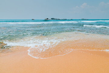 Beautiful seascape with ocean beach. Sandy beach with rocks and reefs at the ocean coast on Sri Lanka island.