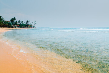 Sunny tropical ocean beach and coral reef at Hikkaduwa, Sri-Lanka.