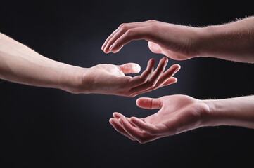 Two hands are holding each other. Symbol of tenderness, care and support by a man of a woman on a...
