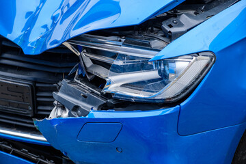 Zerquetschte Front an einem blauen Auto nach einem Autounfall - Details von einem Unfallauto