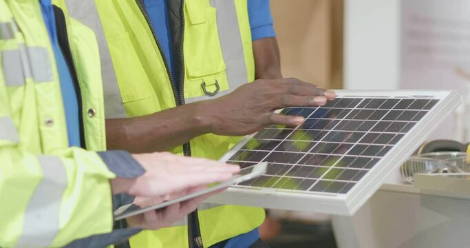 American and African engineer discuss with tablet and solar cell in safety uniform at office. Renewable clean energy alternative source generate electricity from sun. Innovation save energy solar roof