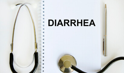 In the notebook is the text of DIARRHEA, next to the stethoscope and pen.