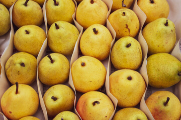 Ripe yellow pears in a wooden box