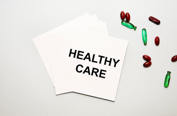 Healthy CARE text on the note sheets, a capsule of red and green is next to it.