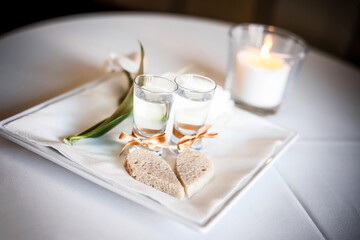 Wedding tradition in Poland and Russia. Parents welcome bride and groom with bread, vodka and salt. Decorative tray with food and alcohol. Empty copy space european culture background.