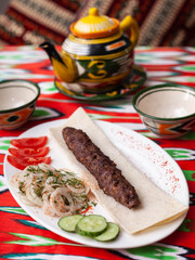 beef and lamb shashlik - grilled meat, minced meat. Served with vegetables, pickled onions, lavash bread