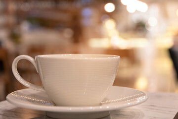 Cup of tea on the table with blur background at cozy cafe and restaurant.