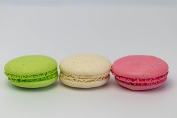 Obraz na płótnie Canvas Macaroons isolated on the white background.Homemade french style colorful macaroons. Green, white, pink cookies.