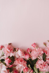 Pink rose flowers bouquet on pink background. Flat lay, top view minimal floral composition.