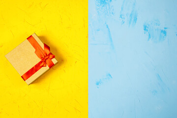 Colored square gift box on concrete background, flat lay, top view