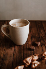 Milk coffee and chocolate on dark wooden background