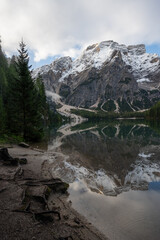 Fototapeta na wymiar View of Mount Seekofel mirroring in the clear calm water of iconic mountain lake Pragser Wildsee (Lago di Braies) in Italy, Dolomites, Unesco World Heritage, South Tyrol