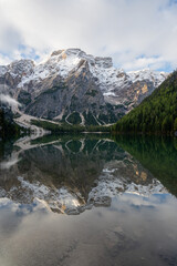 Fototapeta na wymiar View of Mount Seekofel mirroring in the clear calm water of iconic mountain lake Pragser Wildsee (Lago di Braies) in Italy, Dolomites, Unesco World Heritage, South Tyrol