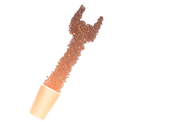 A pile of fresh aromatic coffee beans and a paper mockup of a cup. The concept shows the energy we get when we drink coffee. Place your text or logo. Copy space.